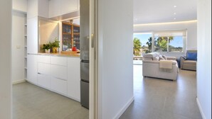 A modern kitchen with white cabinetry, a built-in oven, and a countertop with potted plants. - Canami Luxury Apartment With Best SEA Views (Ses Salines)