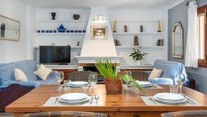 A dining area with a wooden table set for four, surrounded by wicker chairs. - Sa Volta Nova Beautiful House in Countryside (Porreres)