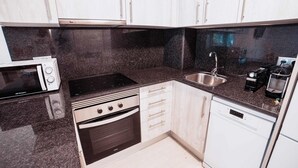 A compact kitchen with a microwave, stove, oven, sink, and dishwasher. - Apartament Reformat a 2 Minuts de la Platja (Palafrugell)