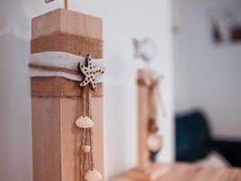 Un poste de madera con un adorno de estrella de mar y conchas marinas.