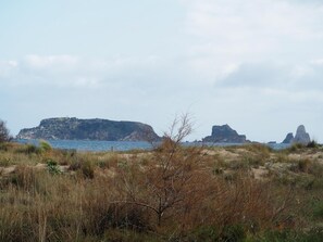 A coastal landscape with rocky outcrops and a lighthouse in the distance. - Apartamento Reformado CON Vistas AL MAR (Torroella de Montgrí)