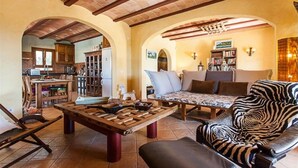 Un salón amplio con una mesa de centro de madera, un sofá estampado con motivos de cebra y una estantería.