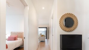 A modern hotel room with a bed, a black TV, and a decorative wall piece. - Apartamento Roca Paraiso DE Agaete CON Vistas (Agaete)