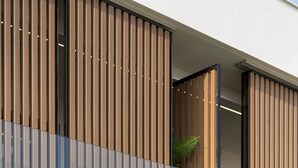 Une façade de bâtiment moderne avec des lambris en bois verticaux et une fenêtre en verre.