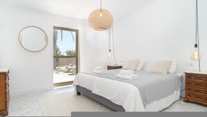 A bedroom with a bed, bedside tables, a dresser, a round mirror, and a hanging light fixture. - CA SA Padrina in Col nia de Sant Jordi (Ses Salines)