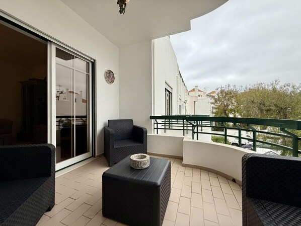 A balcony with a sofa, a small table, and a chair. - Casa Mergoux Maravilhoso Apartamento em Tavira (Tavira)