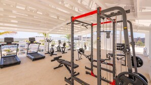 A gym with treadmills, elliptical machines, a squat rack, and free weights. - Waterfront Luxury On Ria Formosa (Olhao)