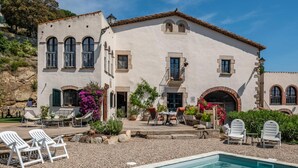 Un grand bâtiment doté d’une piscine, d’un espace extérieur aménagé et d’un jardin.