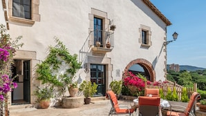 Un bâtiment doté d’un patio comprenant un espace extérieur aménagé avec des sièges et des plantes en pot.