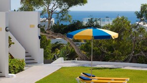 A modern outdoor area with a pool, lounge chairs, and a view of the sea. - Apt 27 Papagayo (Haria)