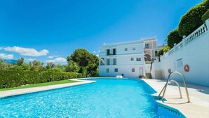 Una piscina con un edificio blanco al fondo.