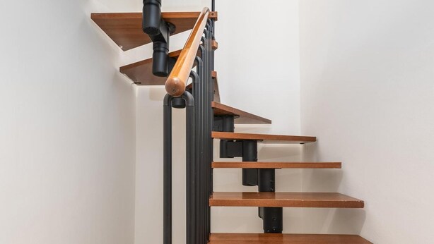 A modern staircase with wooden steps and black metal railings. - Se or o de Aloha 2 Bedroom (Marbella)