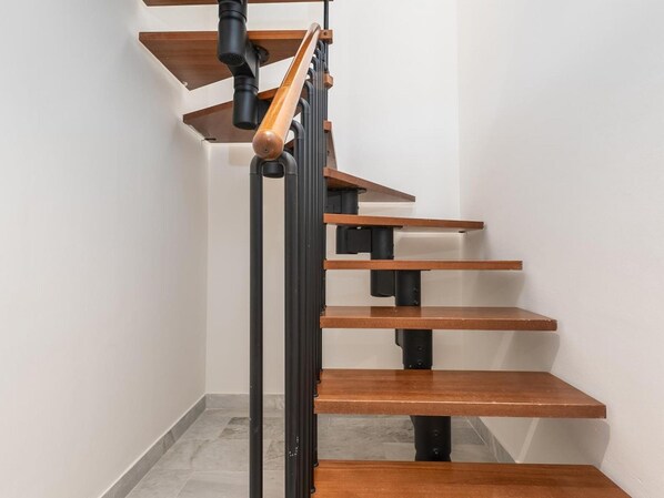A modern staircase with wooden steps and black metal railings. - Se or o de Aloha 2 Bedroom (Marbella)