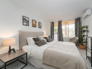 A modern bedroom with a bed, bedside table, lamp, and a window with curtains. - Se or o de Aloha 2 Bedroom (Marbella)
