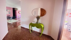 A hallway with a green console table, a mirror, and a vase with dried flowers. - Nerja Sun Apartamento Jabega Torrecilla (Nerja)