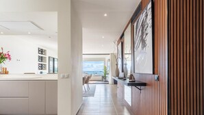 Un intérieur moderne comprenant une cuisine, un coin repas et une vue sur l’extérieur.