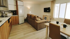 A compact living space with a kitchenette, a sofa, a dining table, and a TV. - Apartamento Bronce A Centro Nerja Sun (Nerja)