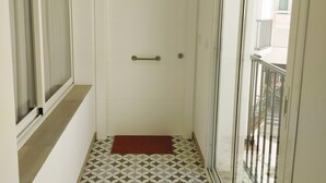 A narrow hallway with a white door, a red mat at the entrance, and a patterned floor. - Apartamento Bronce B Centro Nerja Sun (Nerja)