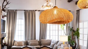 A cozy living room with a wooden dining table, comfortable seating, and decorative candles. - Charming Villa Domingo Playa Portaventura Golf (Cambrils)