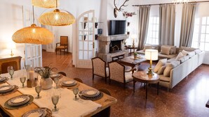 A spacious living room with a fireplace, a dining area set for a meal, and a comfortable seating area. - Charming Villa Domingo Playa Portaventura Golf (Cambrils)