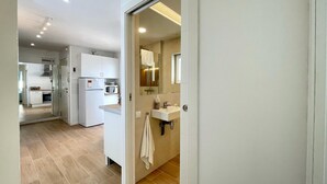 A modern kitchen with white cabinets, a refrigerator, and a microwave. - Precioso Tico Cerca de la Playa y Port Aventura (Salou)