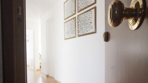 A wooden door with a brass doorknob and a wall with four framed abstract art pieces. - Precioso Tico Cerca de la Playa y Port Aventura (Salou)