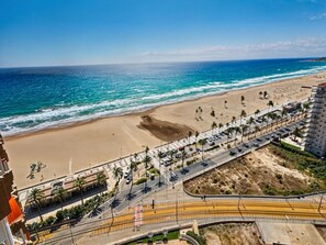 A coastal road with a beach and ocean in the background. - Apartamento N Utico (Alicante)