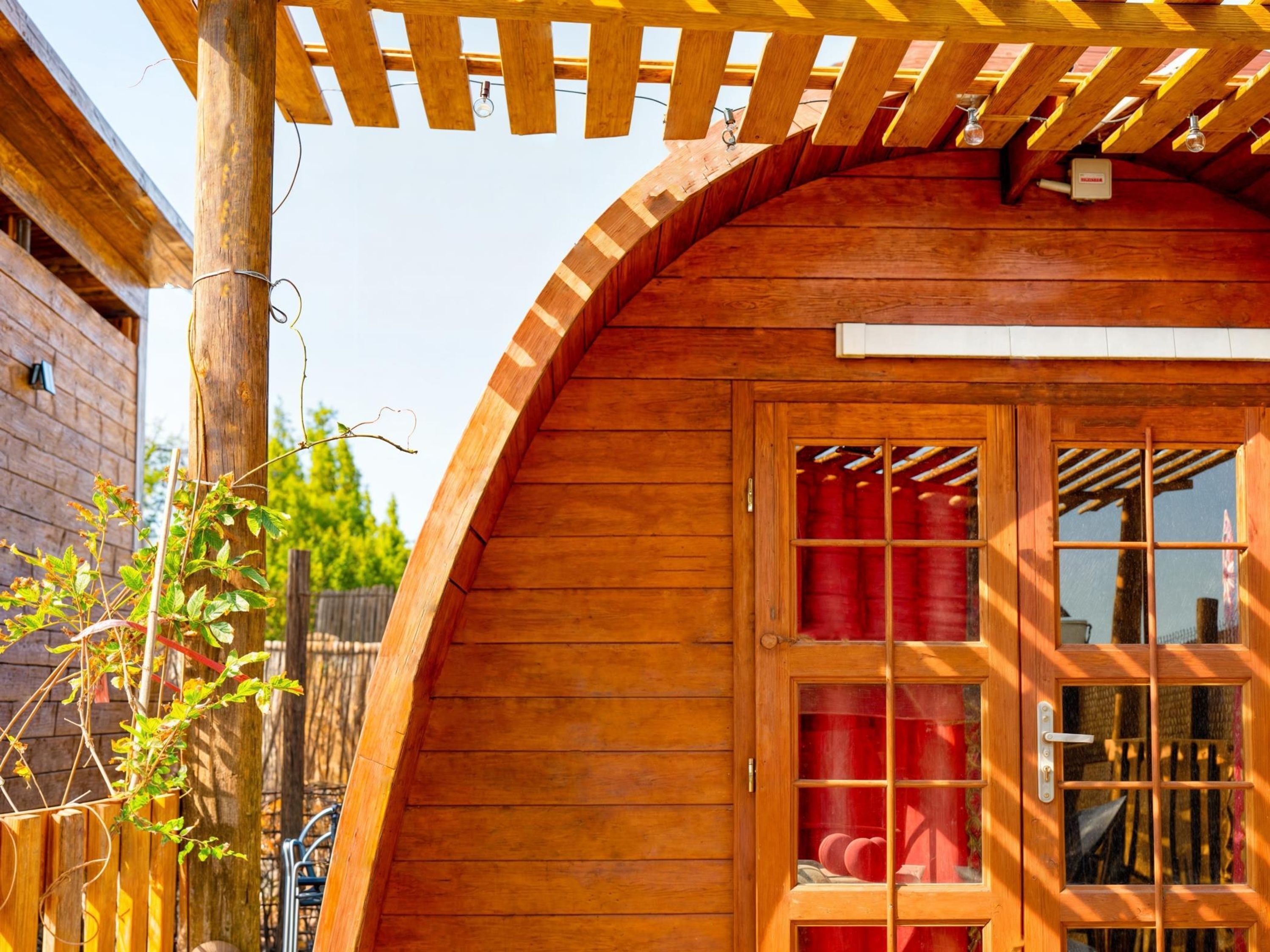 Una casa de madera con techo curvo y porche de madera.