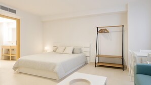 Camera da letto dal design minimalista con un letto, un comodino e una poltrona sospesa.
