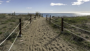 A sandy beach path with wooden posts and ropes, leading to the ocean. - Apartamento Afrodita (Estepona)