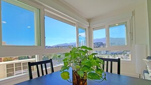 Un comedor con una mesa, sillas y una planta en maceta.
