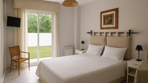 A hotel room with a large bed, a television on the left, a chair, and a view of the outdoors.