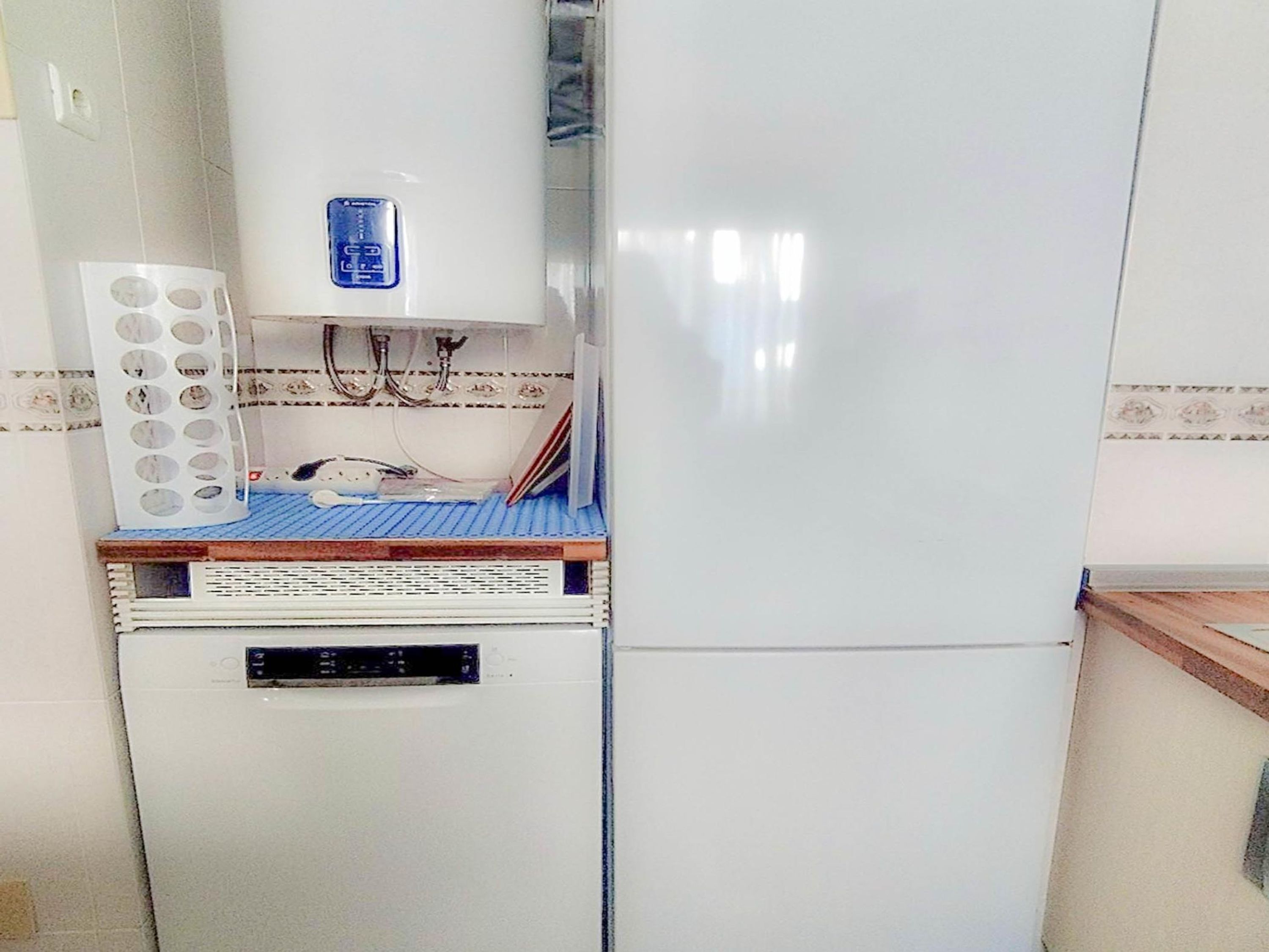 A compact kitchen with a built-in microwave, a small refrigerator, and a sink.