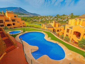 A resort with multiple swimming pools, a mountainous backdrop, and Mediterranean-style architecture. - Apartamento Do a Lucia Resort (Estepona)