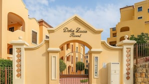 Der Eingang zum Doha Lucia Resort mit einem zentralen Bogen und einem befestigten Zugangsbereich.