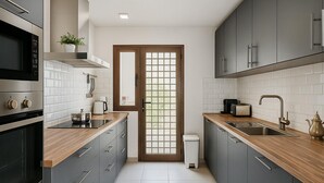 Eine moderne Küche mit grauen Schränken, einer Holz Arbeitsplatte, einem eingebauten Backofen, einer Mikrowelle und einem Spülbecken.