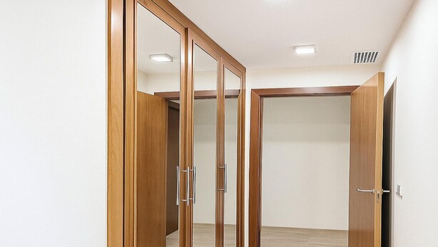 A hallway with wooden wardrobes and a door. - Apartamento Do a Lucia Resort (Estepona)