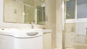 Ein modernes Badezimmer mit Waschbecken, Spiegel und Toilette in Weiß.