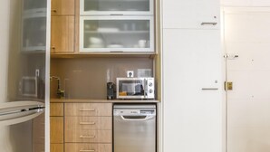 A compact kitchen with a dishwasher, microwave, and a small countertop.
