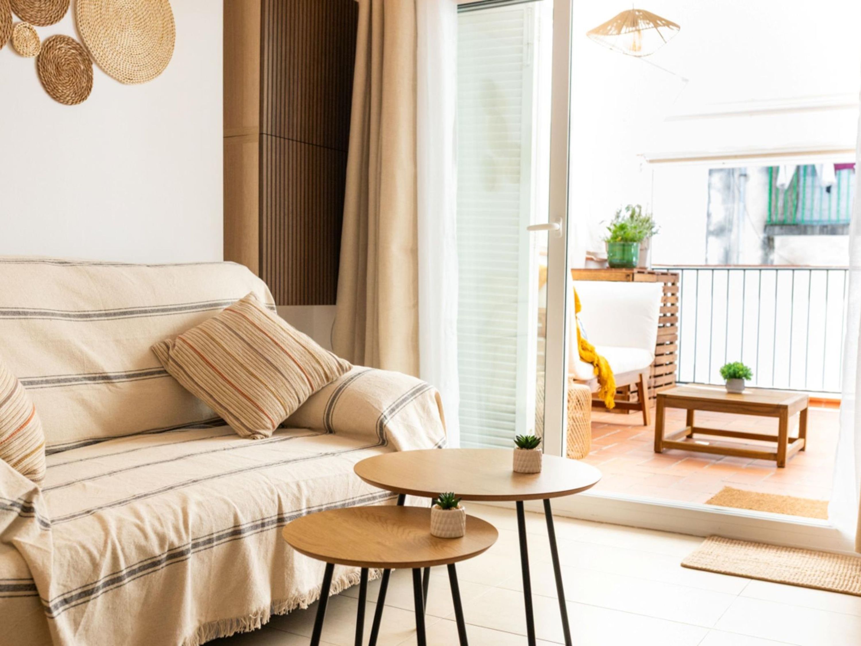Una sala de estar con un sofá, una mesita redonda y vistas a un balcón exterior.