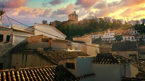 Una città storica con tetti in tegole di terracotta, un'imponente struttura simile a un castello e architettura tradizionale.