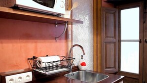 Una cucina accessoriata con forno a microonde, lavello e ciabatta multipresa.