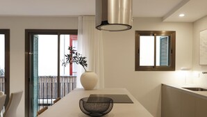 Una cocina moderna con una isla central, una lámpara colgante y vistas al balcón exterior.