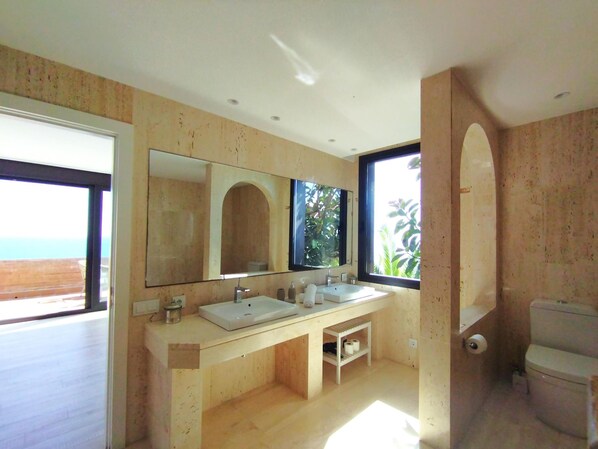 A modern bathroom with a large window, a double sink, and a toilet. - Sitges Spaces Sea View Villa (Sitges)