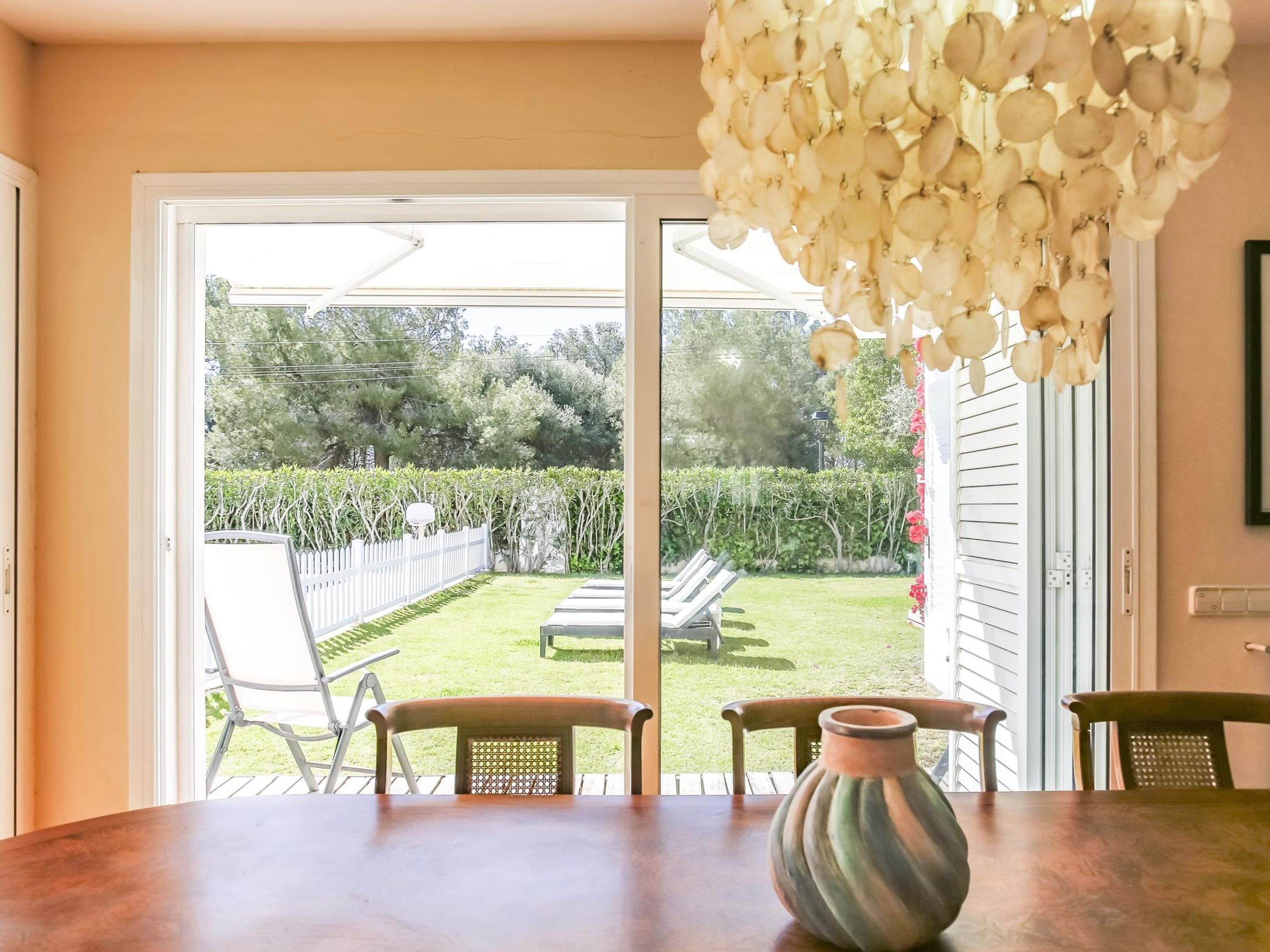 A dining area with a table, chairs, and a vase.