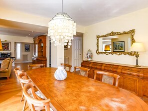 A dining room with a large wooden table, chairs, a chandelier, a mirror, and a cabinet. - Casa Independiente con Jard n y Piscina Privada (Sant Pere de Ribes)