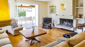 A living room with a sofa, a coffee table, a fireplace, and a television. - Casa Independiente con Jard n y Piscina Privada (Sant Pere de Ribes)