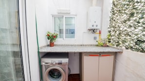 A compact laundry room with a washing machine, a dryer, and a water heater.