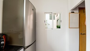 A kitchen with a stainless steel refrigerator, a Bosch toaster, and a wooden door.