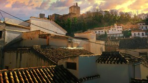 A historic town with traditional architecture, including a prominent castle on a hill and terracotta-tiled rooftops. - Apartamento Rio Genil (Granada)